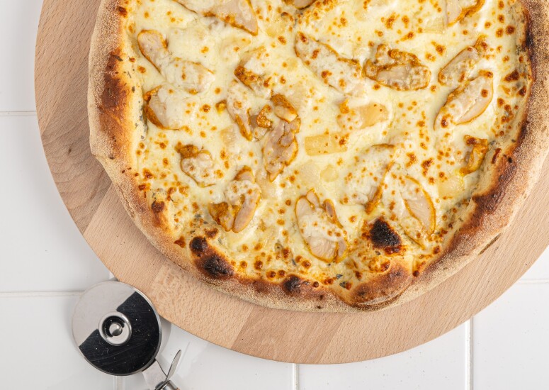 Pizza Poulet Curry ISI, base crème : poulet mariné au curry, oignons pré-frits, mozzarella, origan